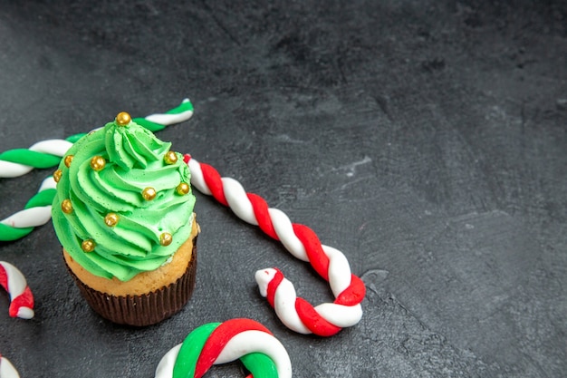 Free photo bottom view mini xmas tree cupcake and xmas candies on dark