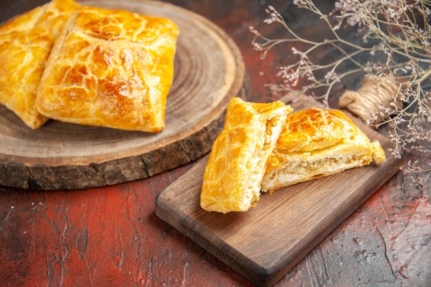 Bottom view penovani khachapuri on wood board and on chopping board on dark red table