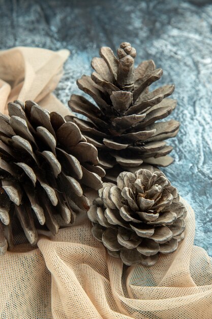 Bottom view pinecones on beige shawl on dark surface