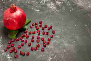 Free photo bottom view a pomegranate pomegranate seeds on dark table free space