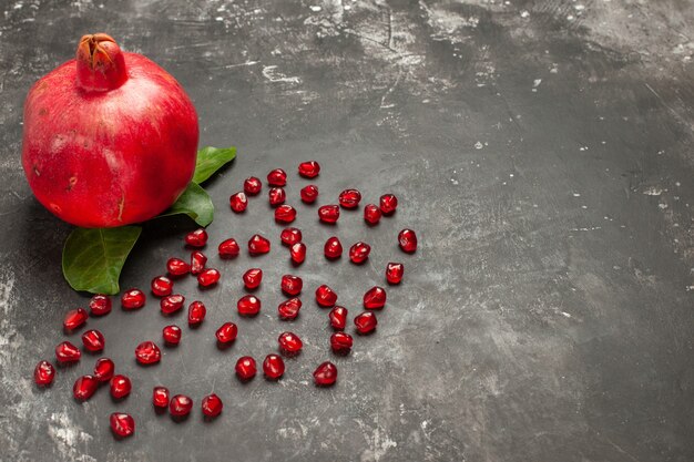 Bottom view a pomegranate pomegranate seeds on dark table free space