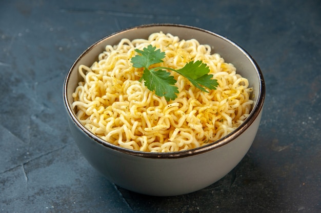 Bottom view ramen noodles with coriander in bowl on dark table