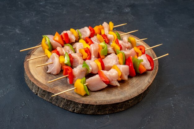 Bottom view raw chicken skewer on wooden board on table