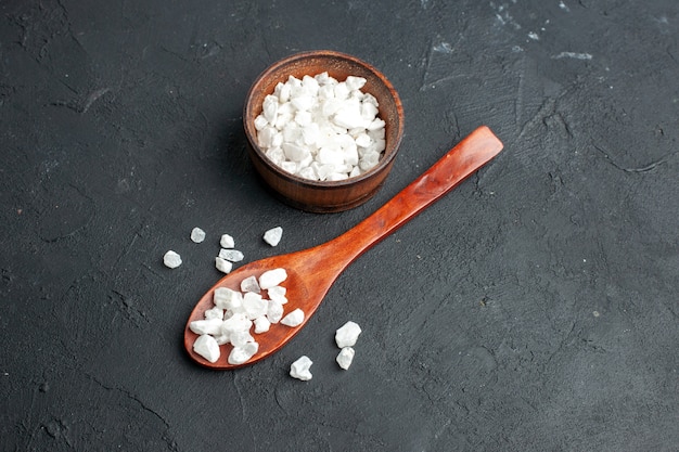 Bottom view sea salt bowl wooden spoon on dark surface free space