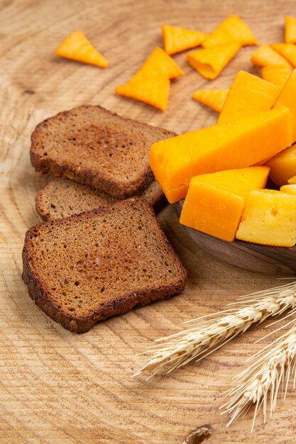 Bottom view slices of cheese slices of bread wheat spike on wooden table