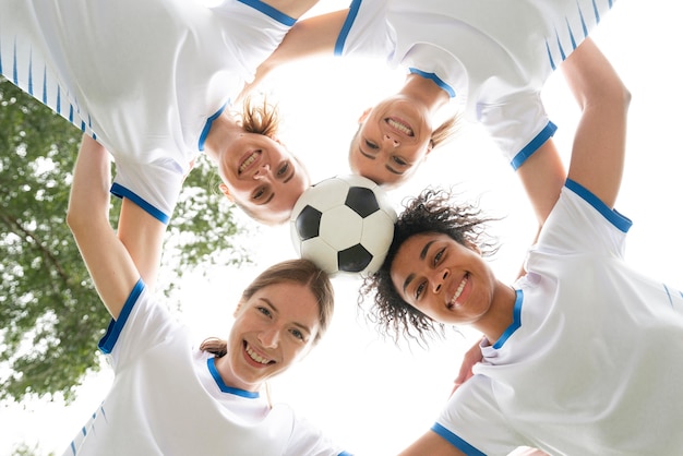 Bottom view smiley women holding ball