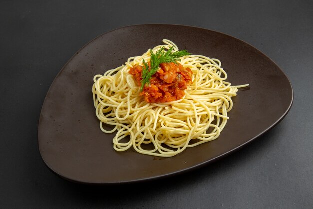 Bottom view spaghetti with sauce on plate on black background