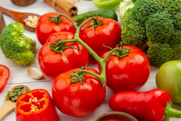 Bottom view tomato branch broccoli wooden spoons garlic on grey table