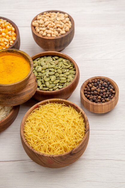 Bottom view wooden bowls with spices and beans on grey table