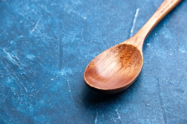 Free photo bottom view wooden spoon on blue surface copy place