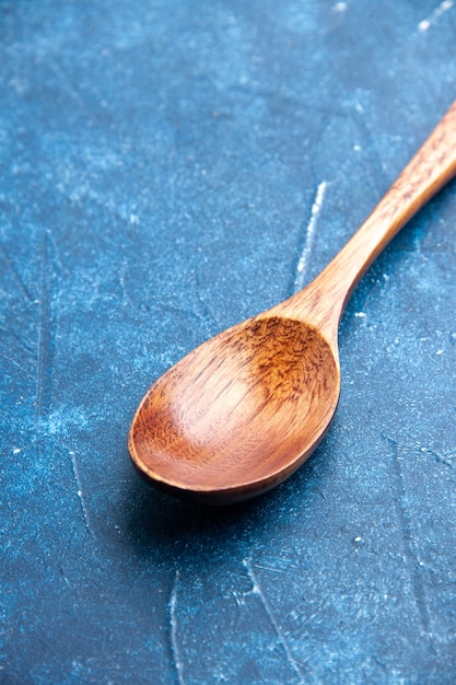 Free photo bottom view wooden spoon on blue table stock photo