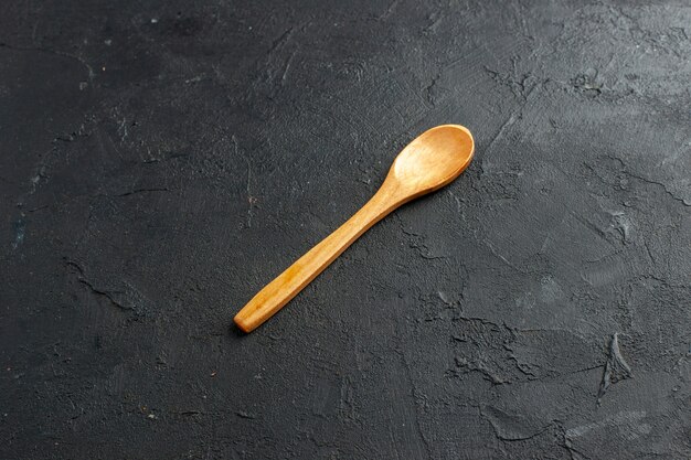 Bottom view wooden spoon on dark table free space