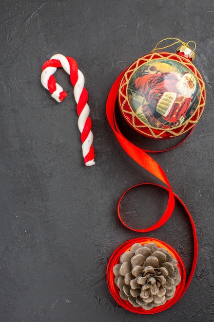 Bottom view xmas gifts in brown paper ribbon xmas tree toy on newspaper on dark background