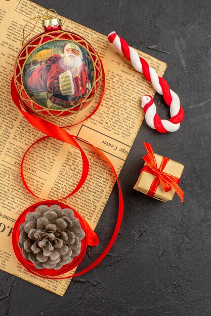 Free photo bottom view xmas gifts in brown paper ribbon xmas tree toy on newspaper on dark background