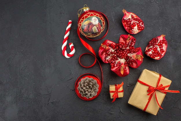 Free photo bottom view xmas gifts in brown paper ribbon xmas tree toy on newspaper on dark