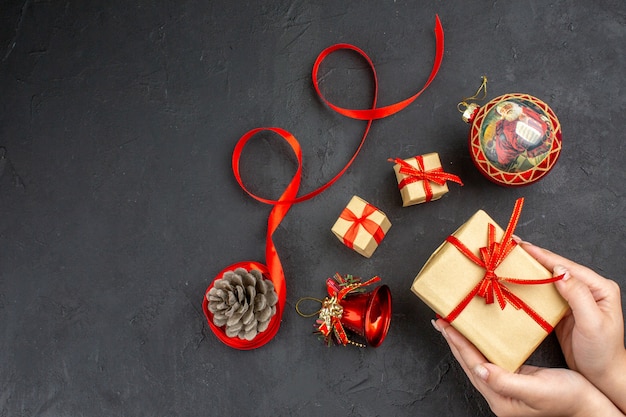 Bottom view xmas gifts in brown paper ribbon xmas tree toys on newspaper on beige background