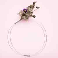 Free photo bouquet of flower tied on metallic wire ring for frame on pink background