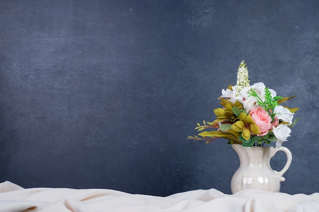 Free photo bouquet of flowers in ceramic vase on dark wall with copyspace.