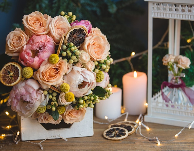 Bouquet of holly berries, peonies and dry lemon slices.