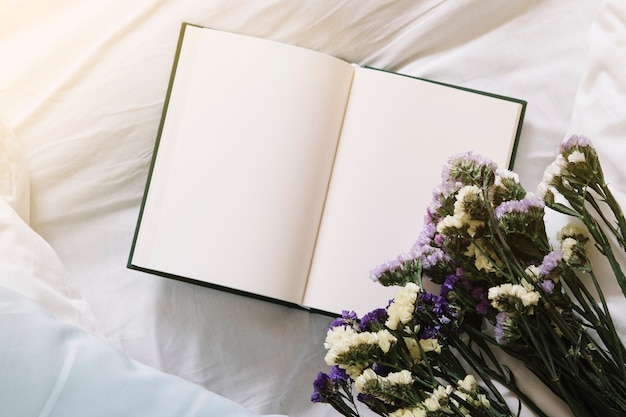 Free Photo bouquet and notebook on bed