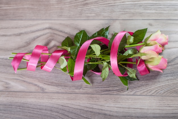 Bouquet of pink roses on wood