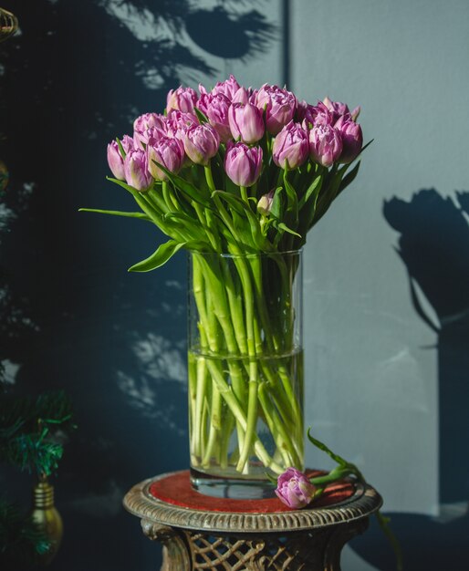 A bouquet of pink tulips with green leaves inside a vase