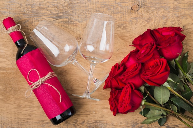 Free photo bouquet of roses glasses and a bottle of wine