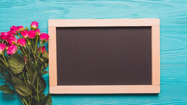 Bouquet of roses near chalkboard