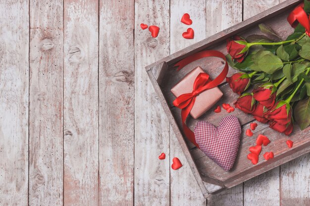 Bouquet of roses on a tray with a heart and a gift