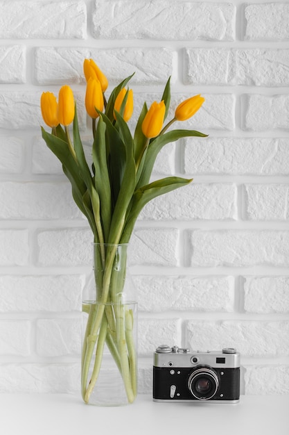 Bouquet of tulips in transparent vase with camera