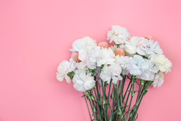 Free photo bouquet of white carnations on a pink background isolated flat lay