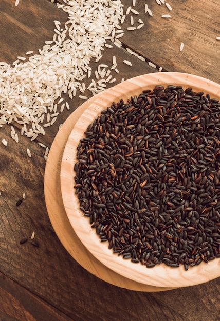 Bowl of brown organic rice grain with white rice on table