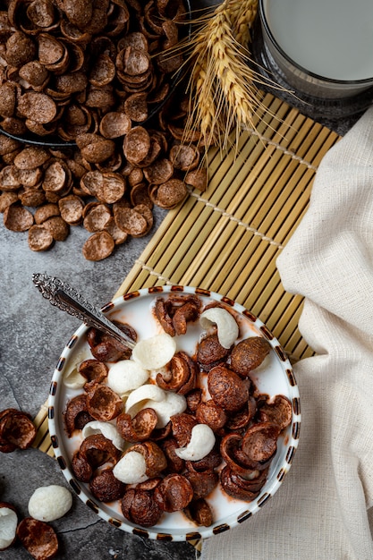 A bowl of cereal, chocolate-flavored cereal mixed with milk for breakfast.