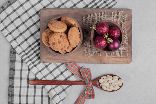 Bowl of chip cookies and Christmas balls on white table. High quality photo