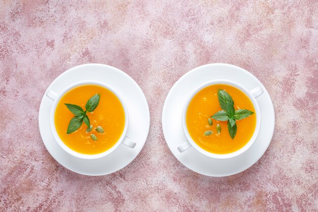 Bowl of delicious pumpkin soup with seeds.