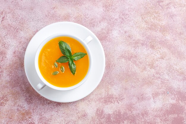 Bowl of delicious pumpkin soup with seeds.