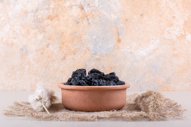 Bowl of dried plum fruits placed on white background. High quality photo