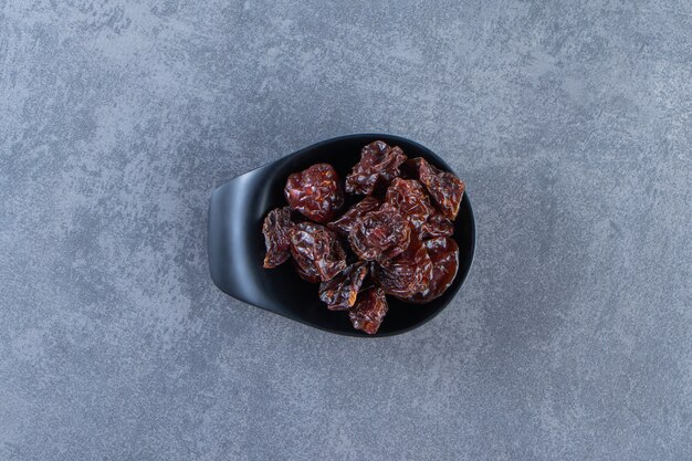 A bowl of dried plum, on the marble background.