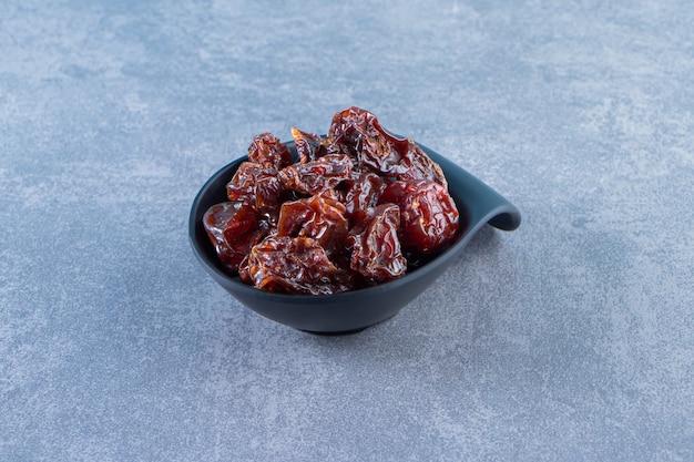 A bowl of dried plum, on the marble surface