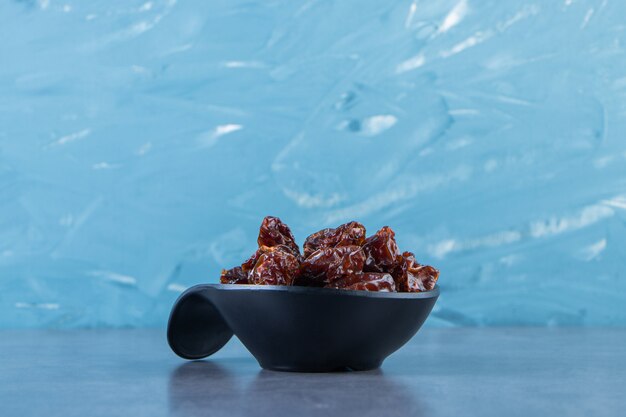 A bowl of dried plum, on the marble surface