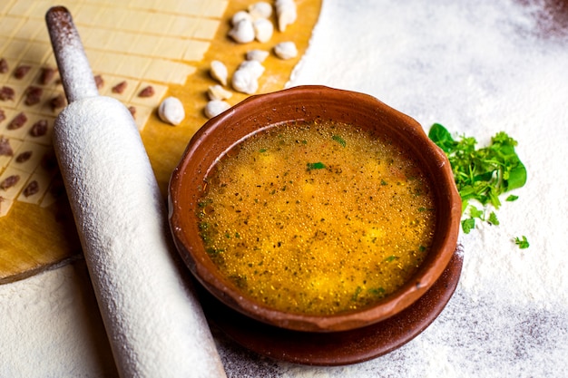 Free Photo a bowl of dushbara dumpling soup near the rolling-pin