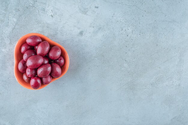 A bowl of fermented plums on the marble surface