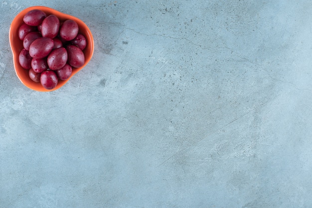 Free Photo a bowl of fermented plums on the marble surface