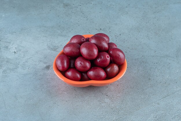 A bowl of fermented plums on the marble surface