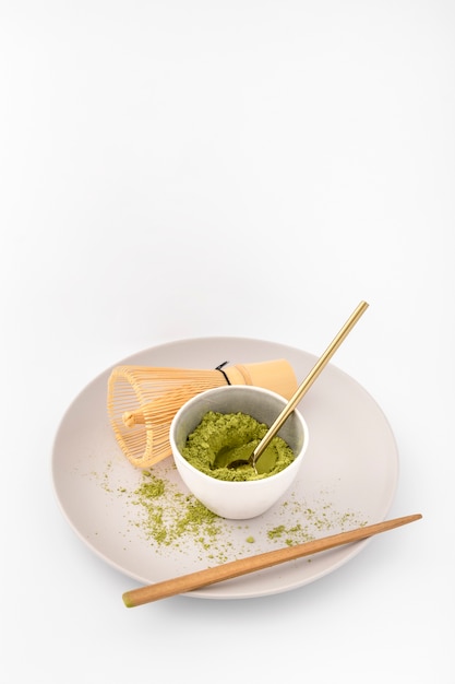 Bowl filled with matcha powder on a plate