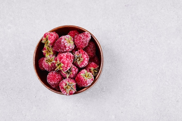 Bowl of fresh red raspberries on white background. 