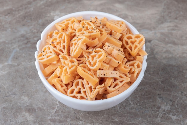 Free photo bowl full of different shaped pasta , on the marble.