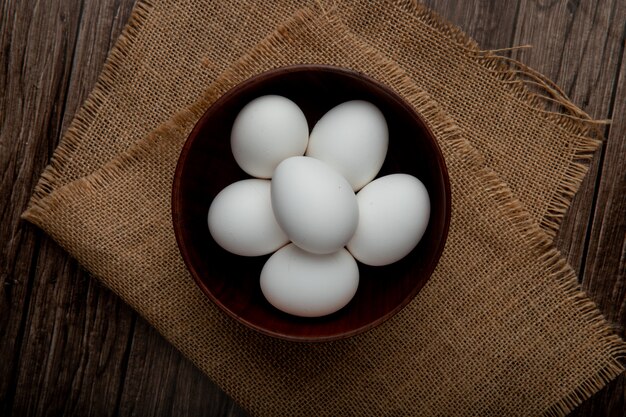  bowl full of eggs on sackcloth surface and wooden table