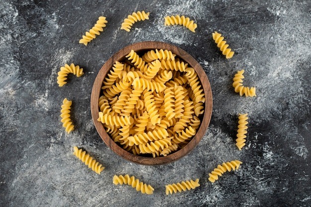 Bowl of fusilli pasta on marble surface