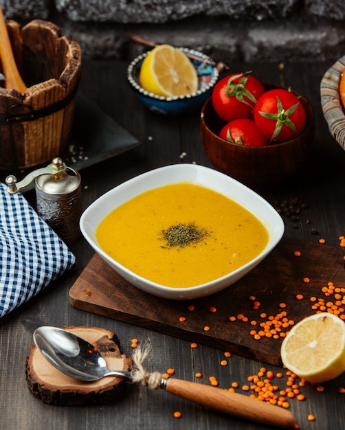 Free Photo a bowl of lentil soup on black wooden table